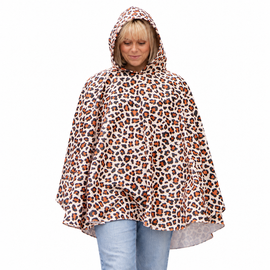 Woman wearing the Hooman Lenny Leopard waterproof rainfleece poncho with the hood up - Hugo and Ted