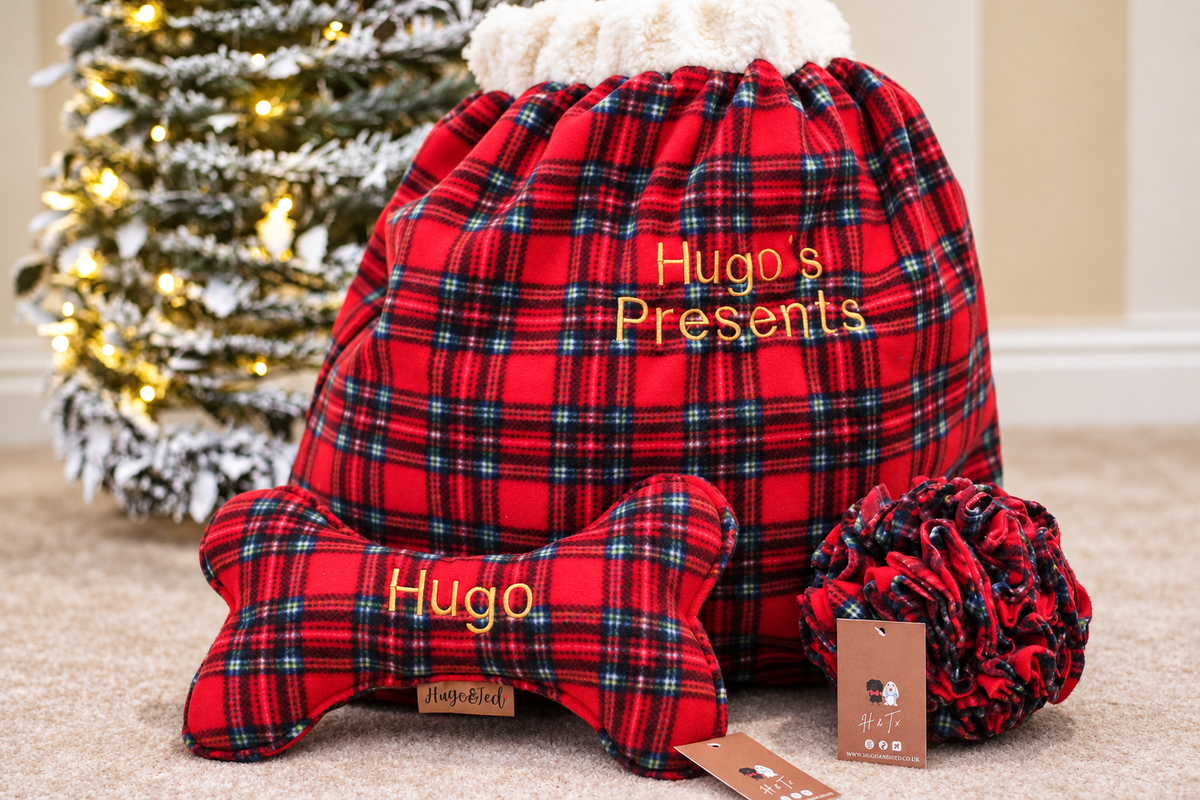 Red tartan wonky bone in front of a red tartan present sack under a Christmas tree