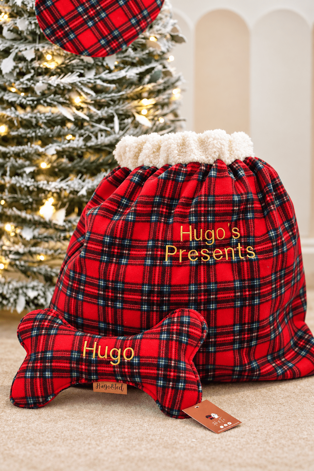 Red tartan wonky bone and present sack in front of a Christmas tree